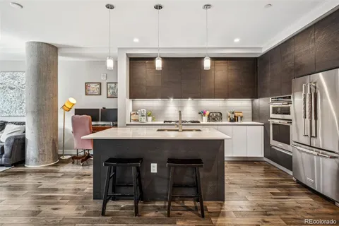 a kitchen with kitchen island a refrigerator stove and sink