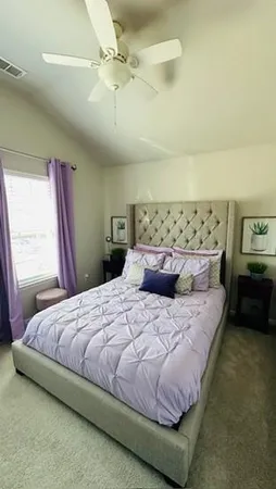 a large bed sitting in a bedroom next to a window