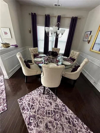 a room with a table chairs and wooden floor