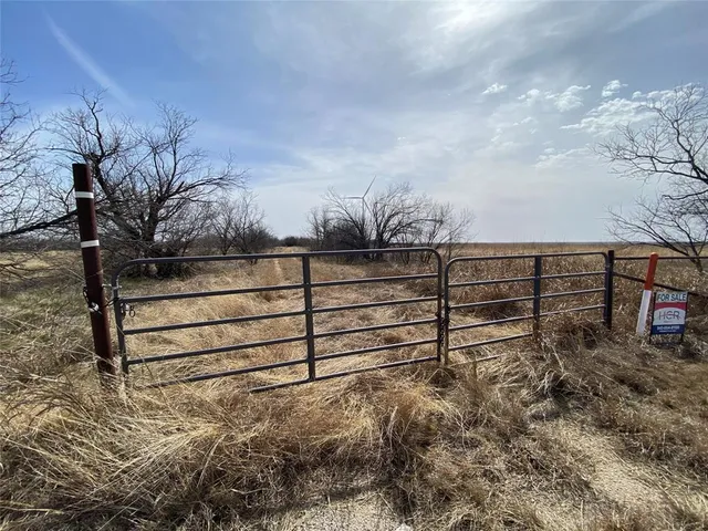 a view of a yard with wooden fence