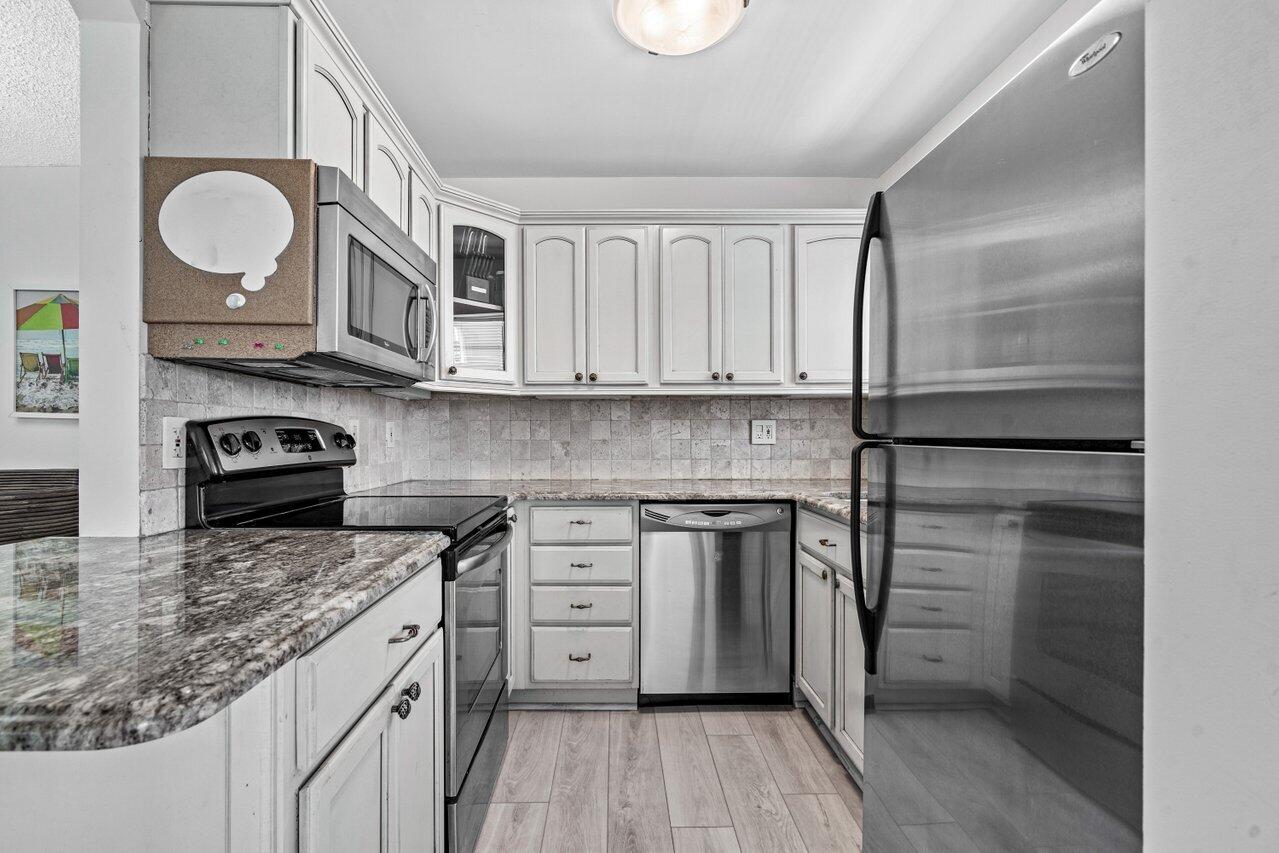 2871 North Ocean Boulevard, Unit C417 Boca Raton, FL 33431 - Photo 13 of 26 a kitchen with stainless steel appliances granite countertop a stove a sink and a refrigerator