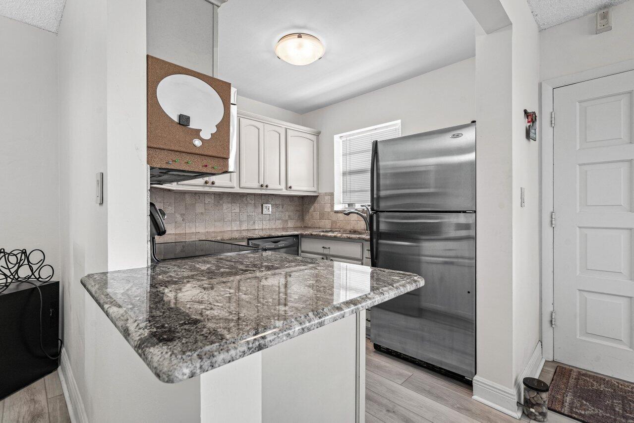 2871 North Ocean Boulevard, Unit C417 Boca Raton, FL 33431 - Photo 13 of 26 a kitchen with granite countertop a sink and a stove