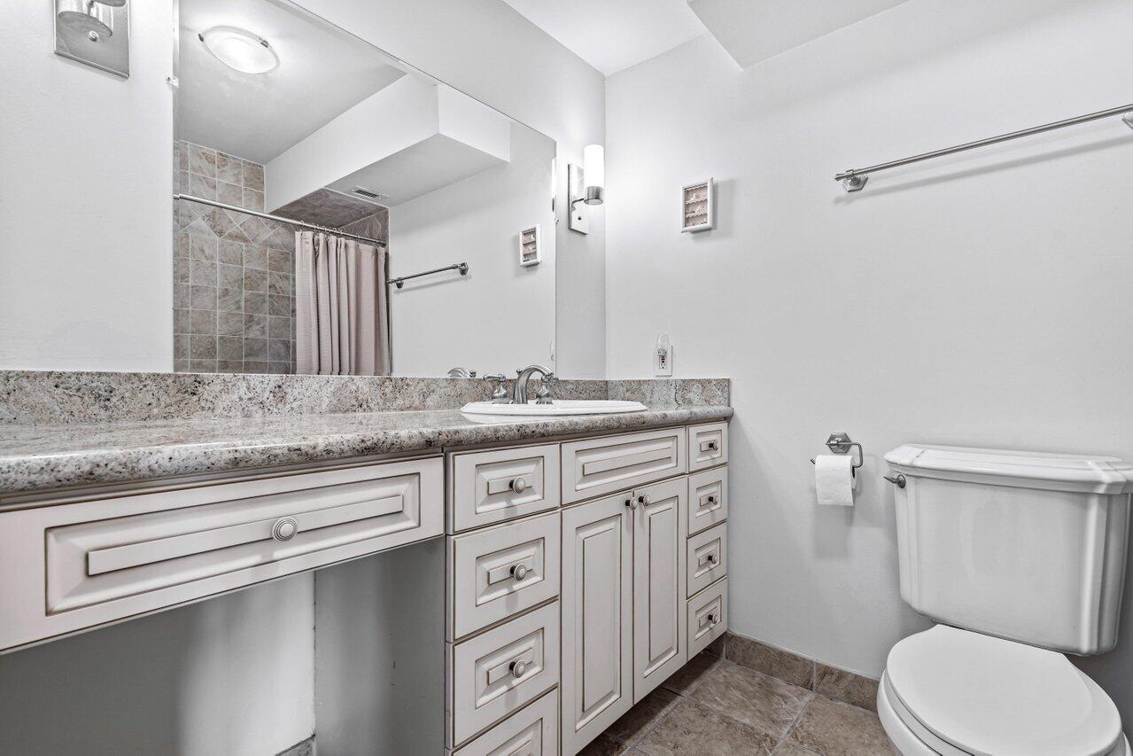 2871 North Ocean Boulevard, Unit C417 Boca Raton, FL 33431 - Photo 14 of 26 a bathroom with a granite countertop toilet sink and mirror