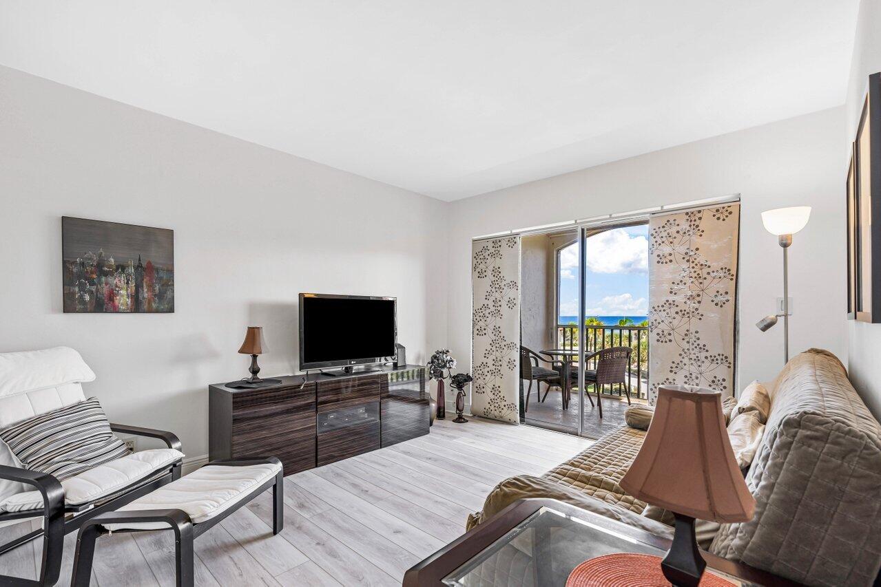 2871 North Ocean Boulevard, Unit C417 Boca Raton, FL 33431 - Photo 15 of 26 a living room with furniture and a flat screen tv with wooden floor