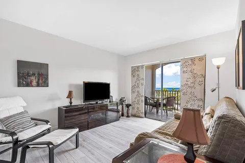 a living room with furniture and a flat screen tv with wooden floor