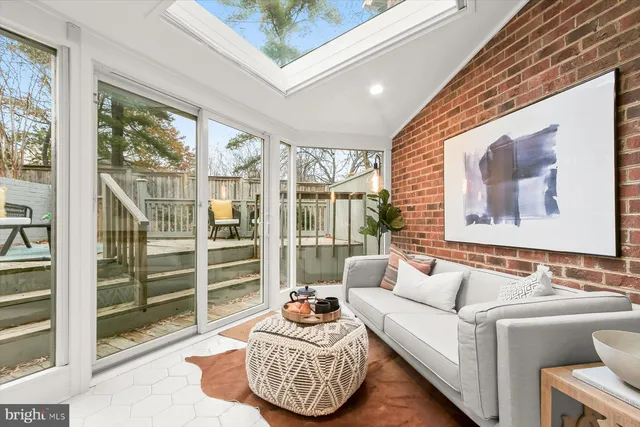 a living room with furniture a large window and cabinets