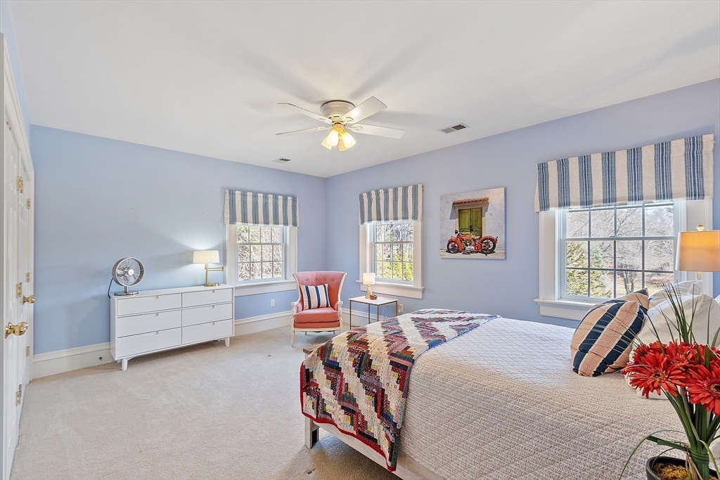 287 Westford Road Concord, MA 01742 - Photo 32 of 42 a spacious bedroom with a bed and a chandelier