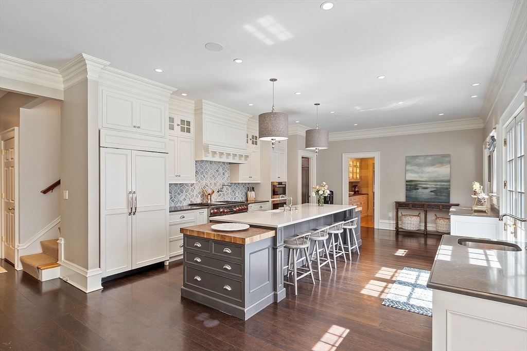 287 Westford Road Concord, MA 01742 - Photo 8 of 42 a kitchen with stainless steel appliances a stove a refrigerator and a dining table with wooden floor