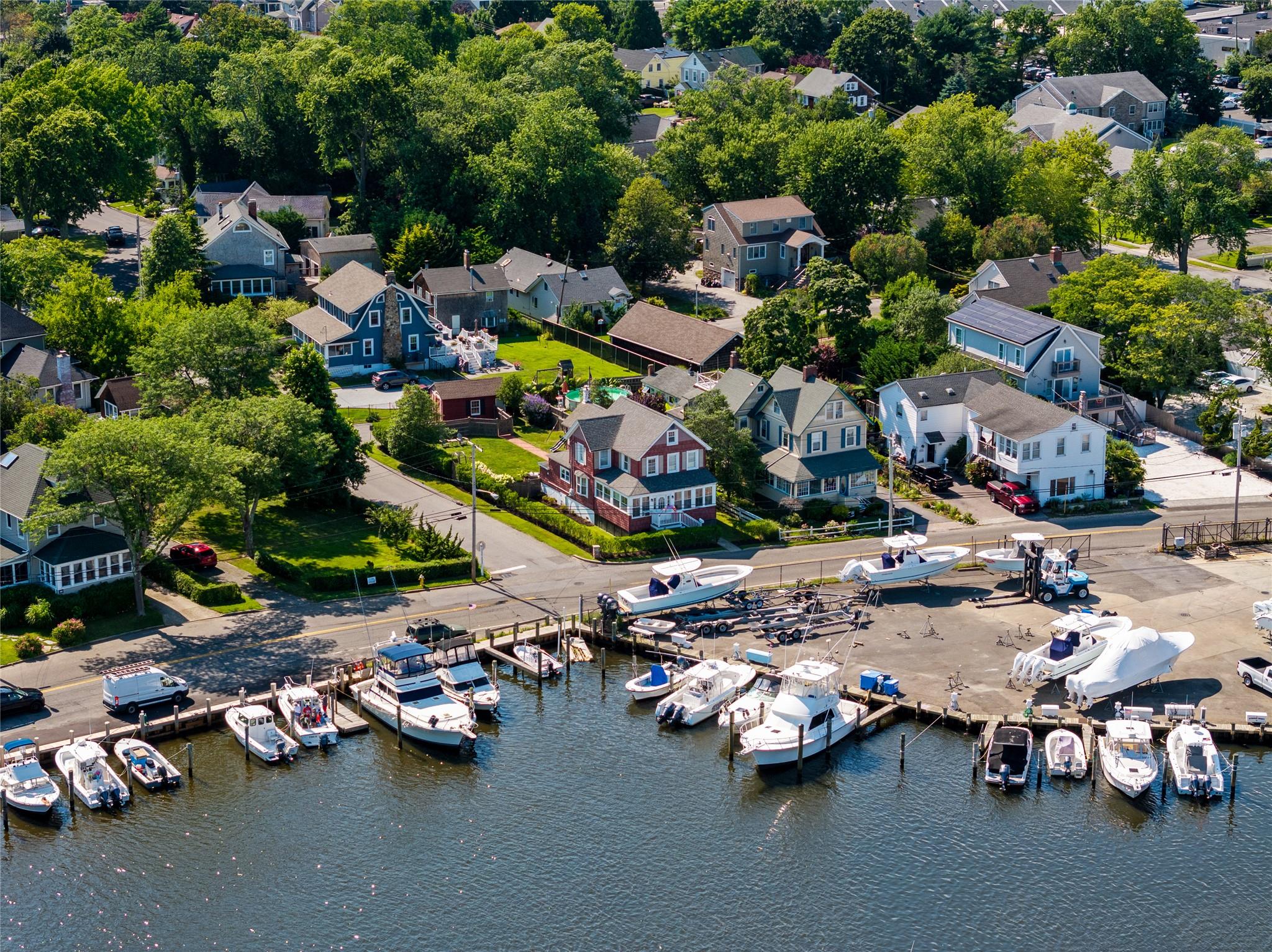 Aerial view of residential area featuring a nearby body of water and numerous boat docks