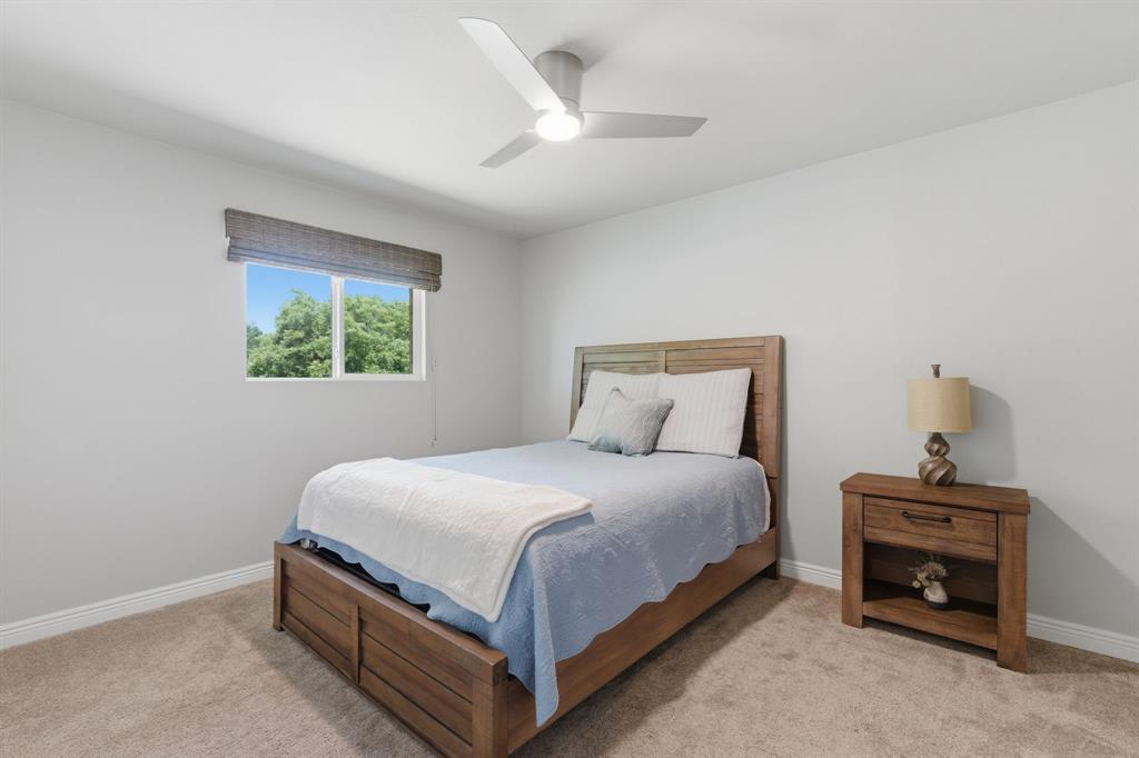 10390 Ridgecrest Street Frisco, TX 75033 - Photo 28 of 40 a bedroom with a bed and a chandelier