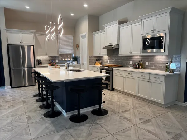 a kitchen with a sink appliances and cabinets