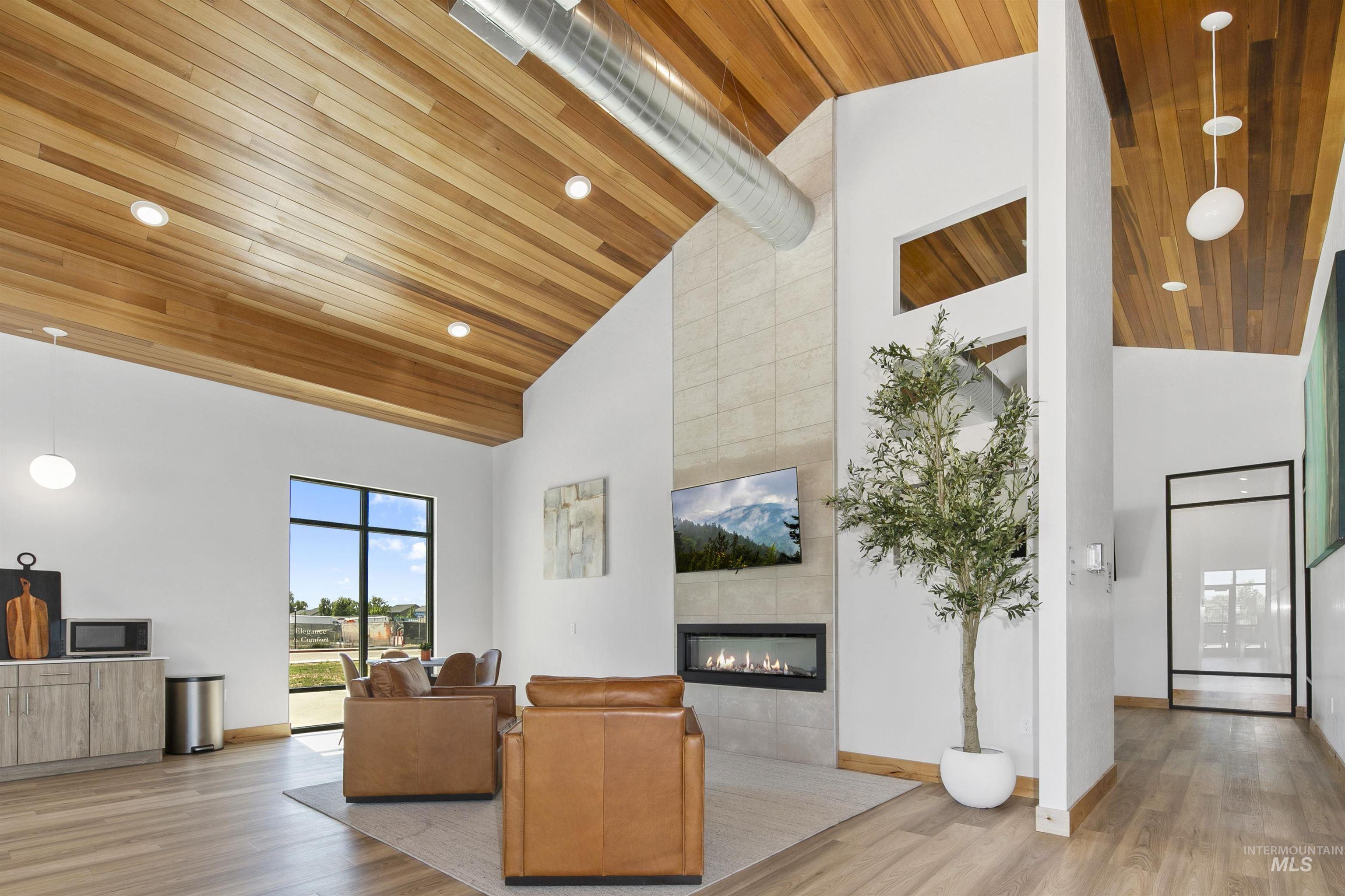 683 West Wrangler Street Meridian, ID 83646 - Photo 7 of 11 Living room with light wood-style floors, high vaulted ceiling, a tiled fireplace, wood ceiling, and recessed lighting