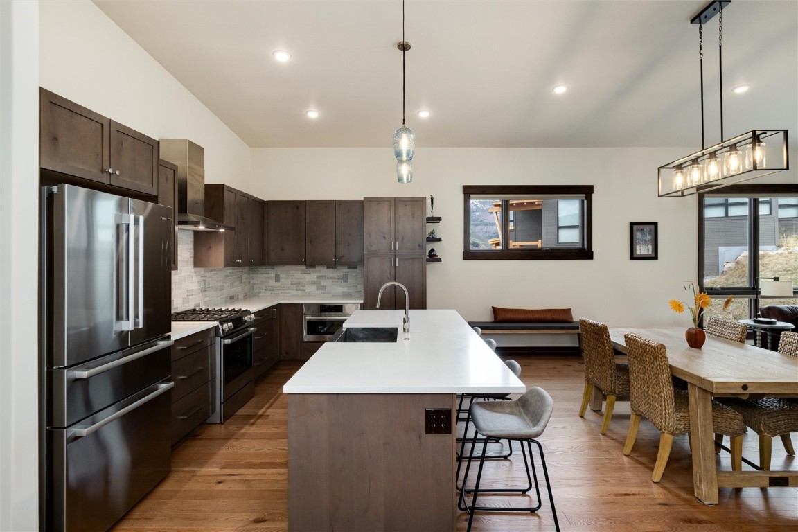 17 Vendette Road Silverthorne, CO 80498 - Photo 14 of 50 a kitchen with a refrigerator a stove a sink dishwasher a dining table and chairs with wooden floor