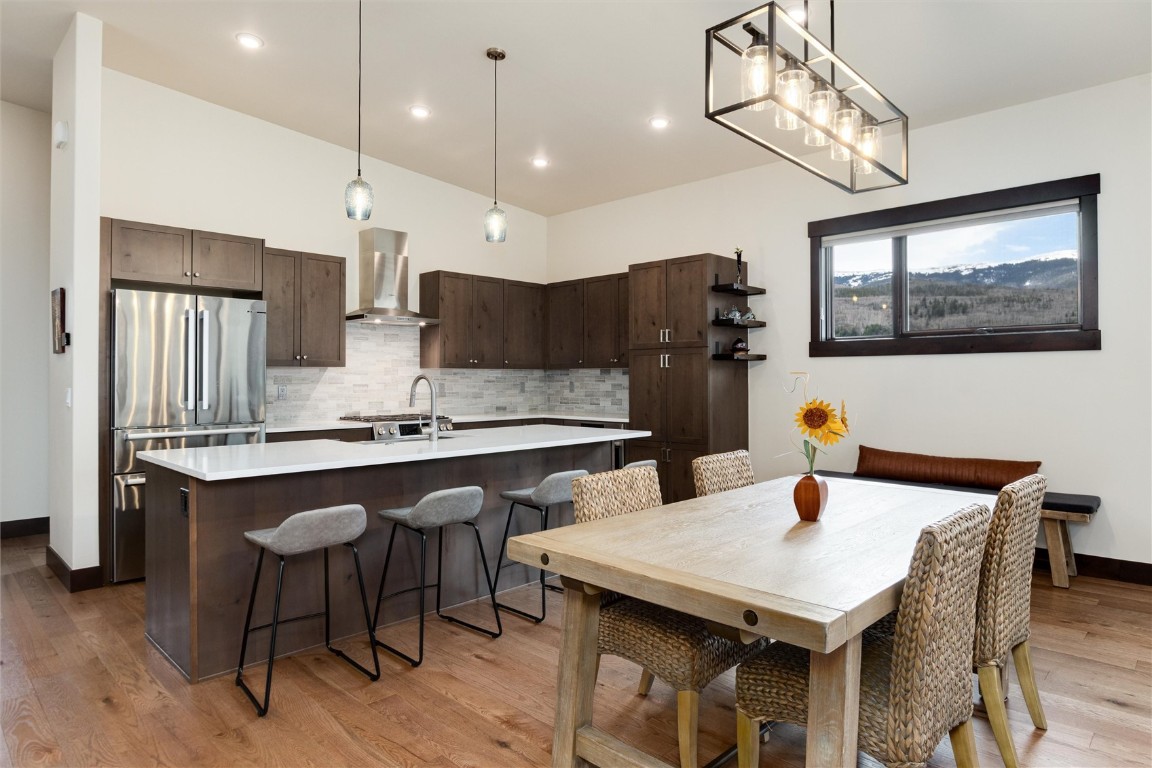17 Vendette Road Silverthorne, CO 80498 - Photo 16 of 50 a kitchen with stainless steel appliances kitchen island granite countertop a table chairs in it and wooden floors