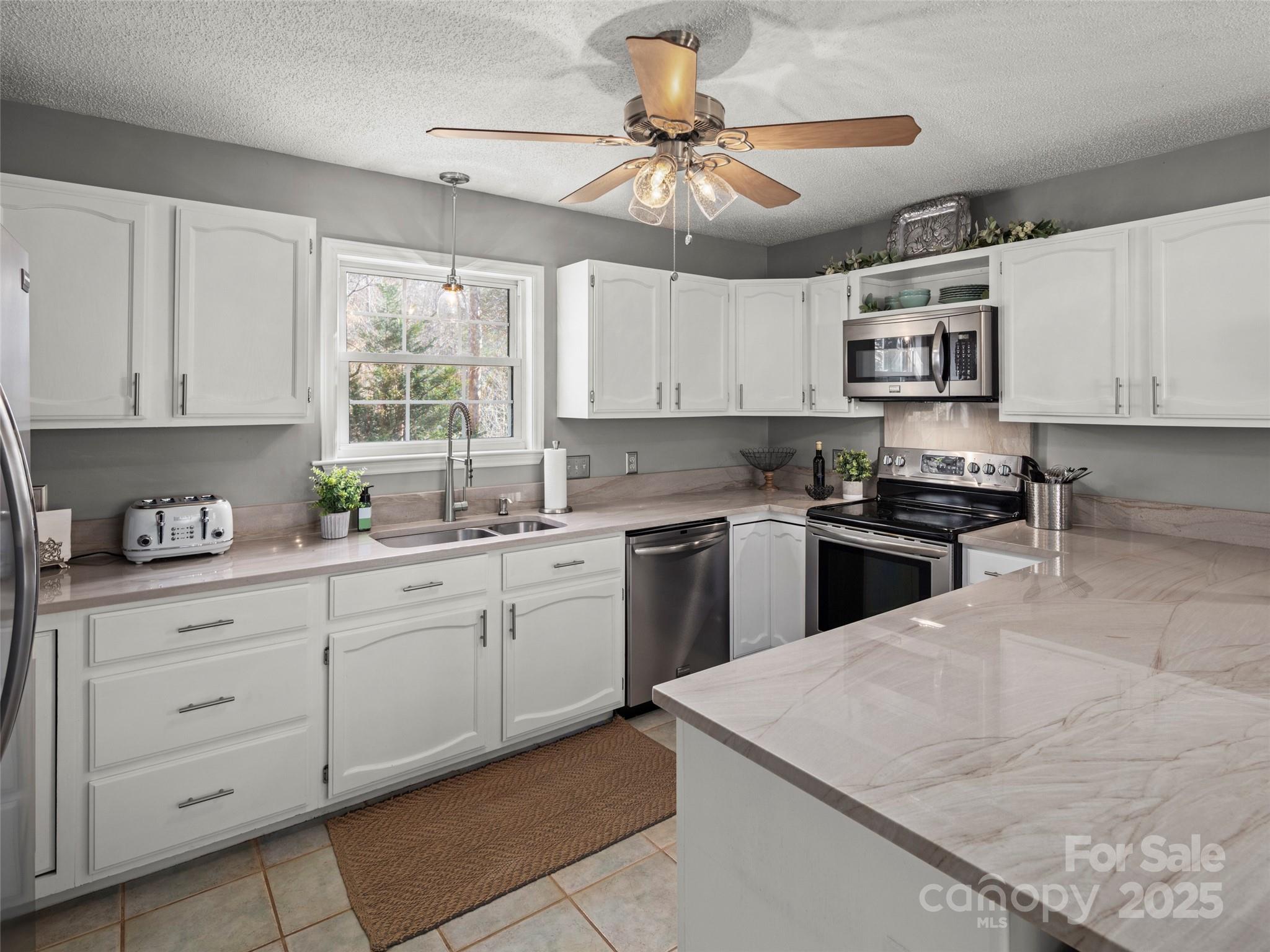 33 Ivy Cove Road Fairview, NC 28730 - Photo 13 of 36 a kitchen with granite countertop a stove sink and cabinets
