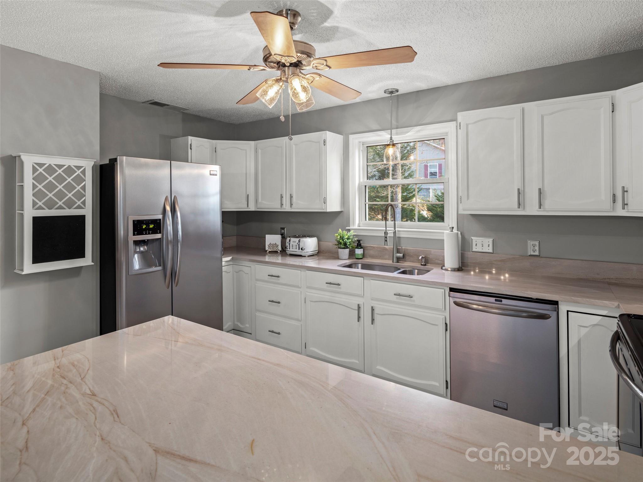 33 Ivy Cove Road Fairview, NC 28730 - Photo 16 of 36 a kitchen with stainless steel appliances granite countertop a refrigerator a sink dishwasher a stove and white cabinets