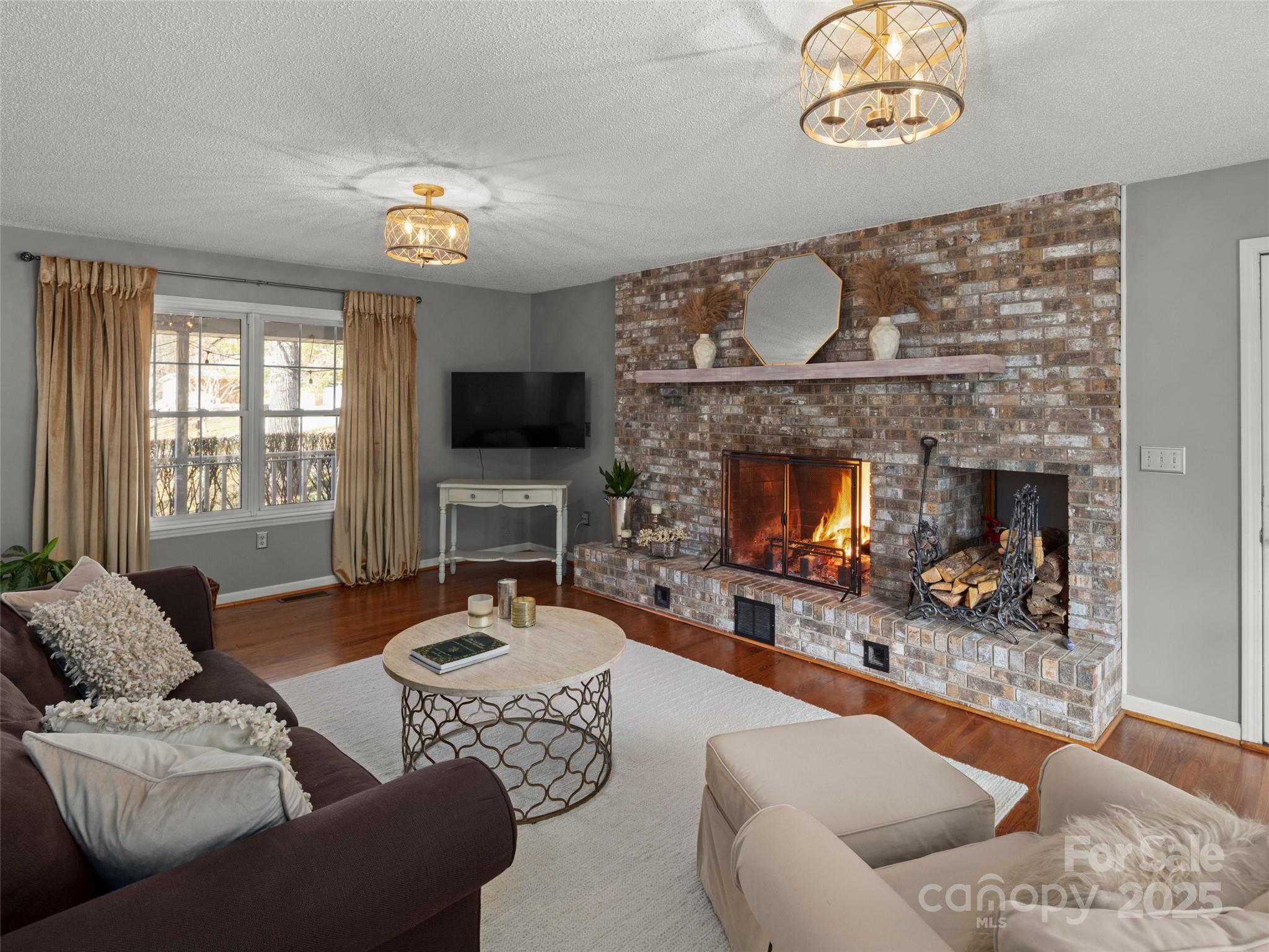 33 Ivy Cove Road Fairview, NC 28730 - Photo 8 of 36 a living room with furniture a fireplace and a flat screen tv