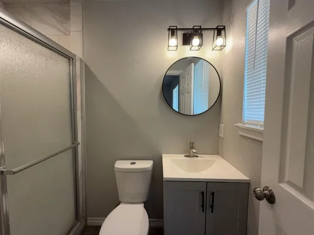 a bathroom with a toilet sink and mirror