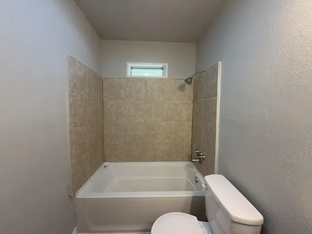 a bathroom with a toilet and bathtub