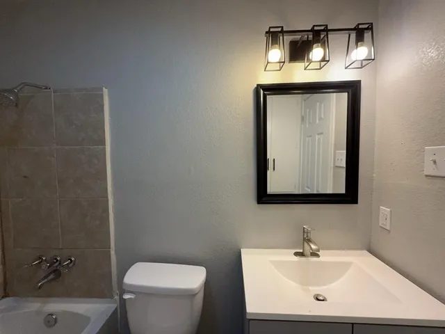 a bathroom with a toilet a sink and mirror