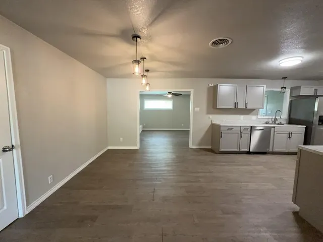 a view of a kitchen with stainless steel appliances a refrigerator and a sink
