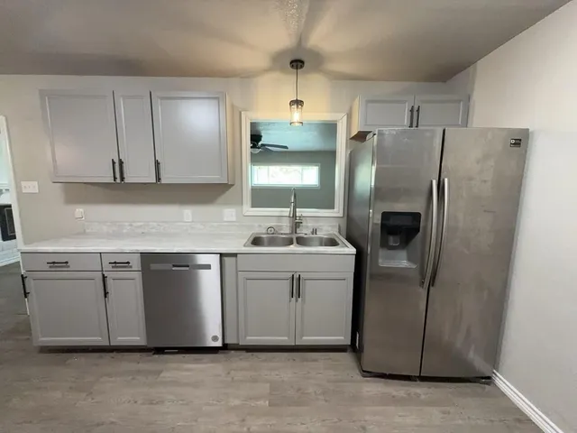 a kitchen with stainless steel appliances granite countertop a refrigerator a sink and dishwasher