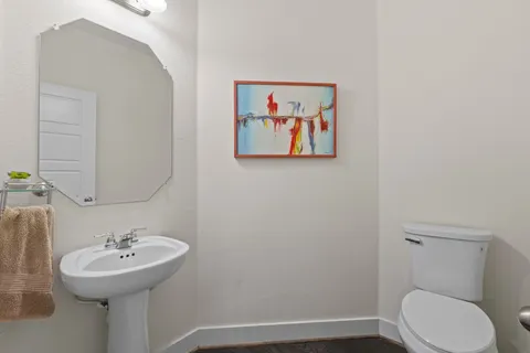 a bathroom with a sink mirror and toilet
