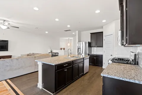 a kitchen with a stove sink and cabinets