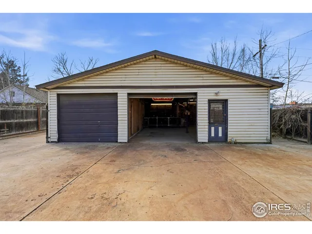 a view of a house with a small yard and wooden fence