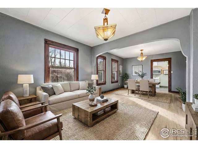 a living room with furniture a chandelier and a window