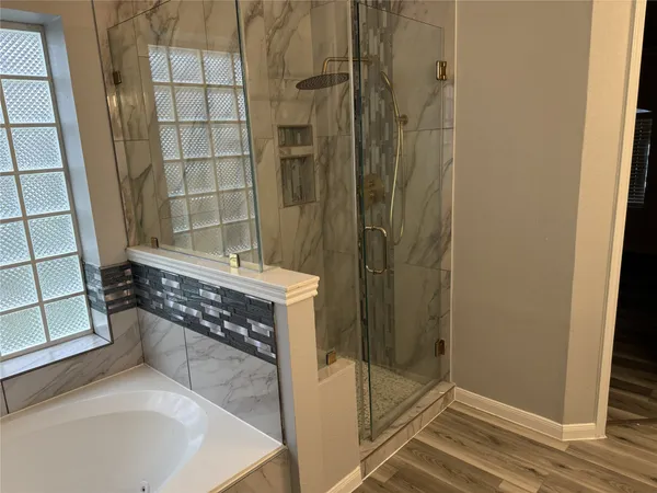 a bathroom with a tub and shower