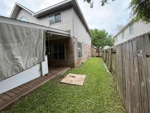 a view of a house with backyard and a tree