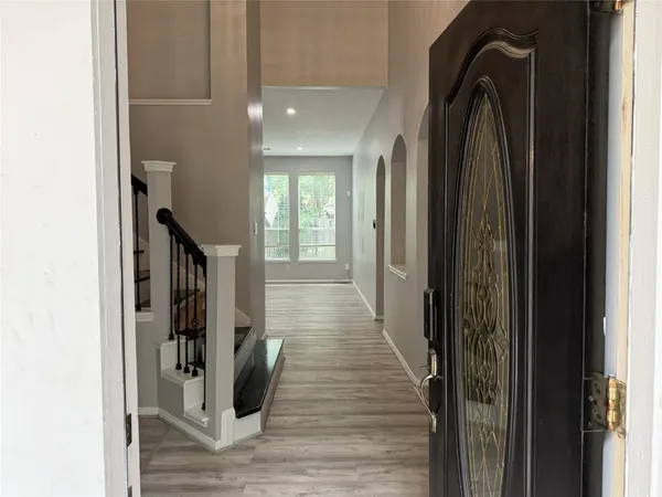 a view of a hallway with wooden floor and staircase