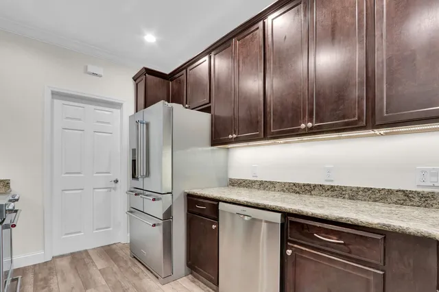 a kitchen with stainless steel appliances granite countertop a refrigerator and a stove top oven