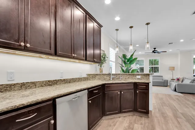 a kitchen with granite countertop stainless steel appliances a sink a counter space and cabinets