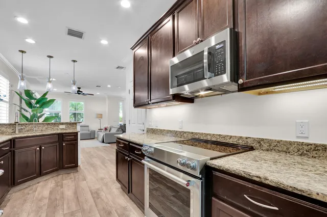 a kitchen with stainless steel appliances granite countertop a stove a sink and a microwave