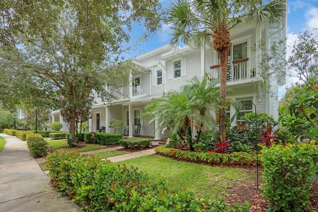 a front view of a house with a yard and tree