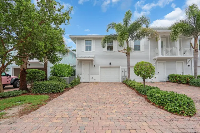 a front view of a house with a yard and a garage