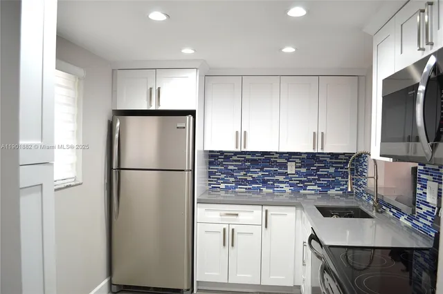 a kitchen with a refrigerator and a stove top oven