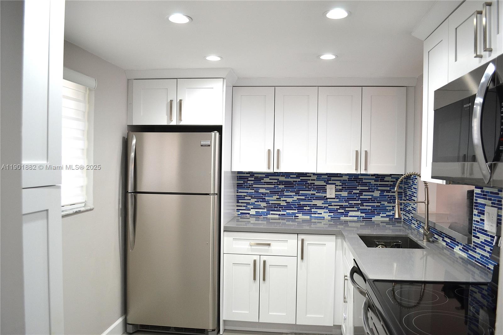 a kitchen with a refrigerator and a stove top oven