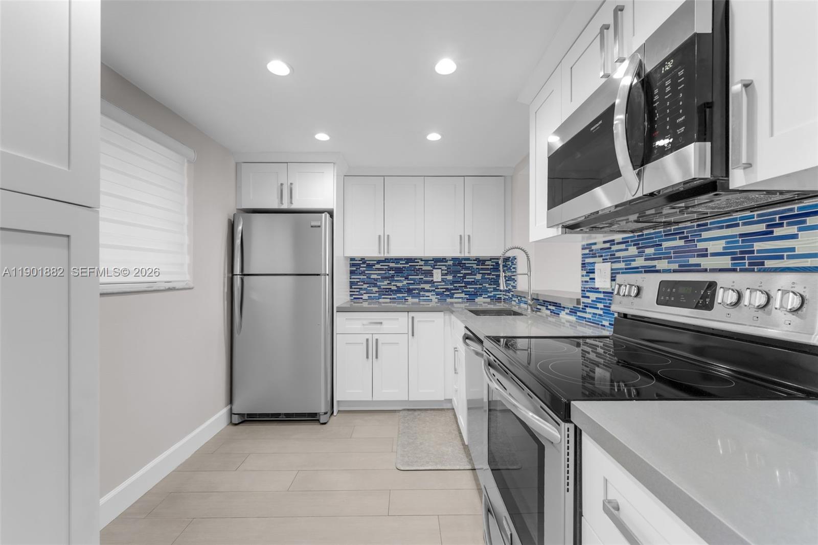 a kitchen with a refrigerator sink and cabinets