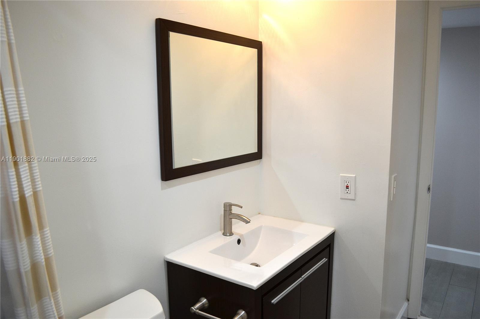 8045 Southwest 107th Avenue, Unit 303 Miami, FL 33173 - Photo 11 of 26 a bathroom with a sink and a mirror