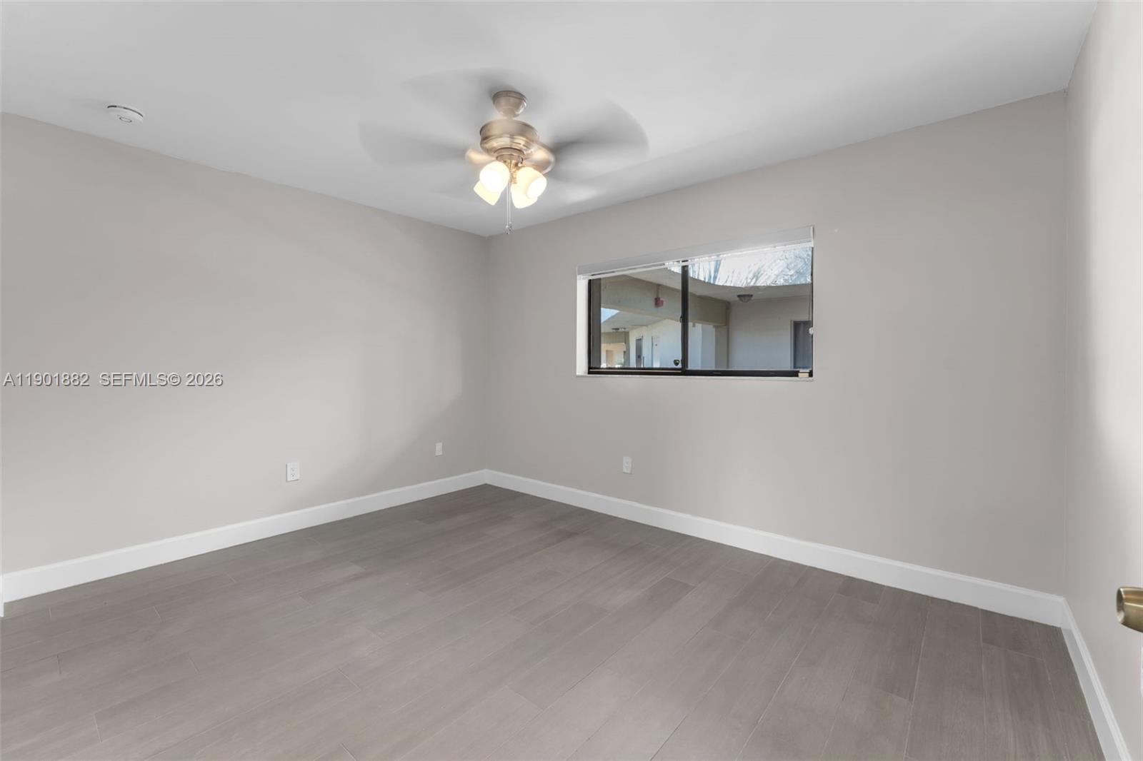 8045 Southwest 107th Avenue, Unit 303 Miami, FL 33173 - Photo 12 of 37 an empty room with a chandelier fan