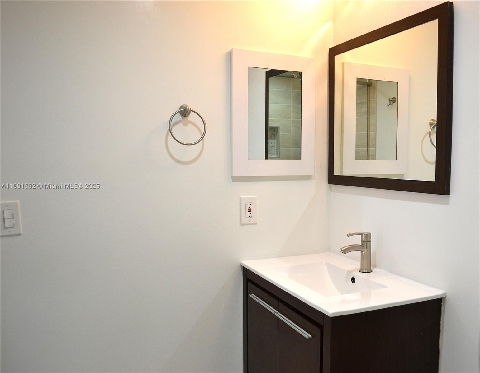 8045 Southwest 107th Avenue, Unit 303 Miami, FL 33173 - Photo 16 of 26 a bathroom with a sink vanity and mirror