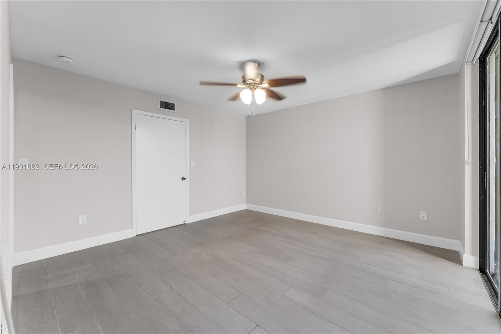 8045 Southwest 107th Avenue, Unit 303 Miami, FL 33173 - Photo 17 of 37 wooden floor in an empty room with a window