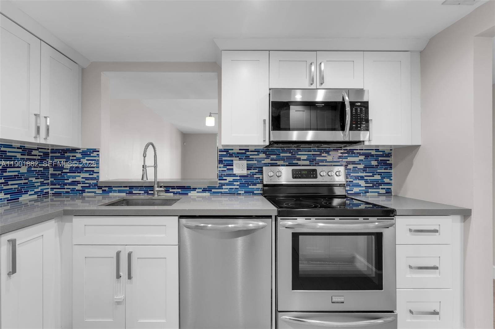 8045 Southwest 107th Avenue, Unit 303 Miami, FL 33173 - Photo 2 of 37 a kitchen with stainless steel appliances granite countertop a stove microwave and cabinets