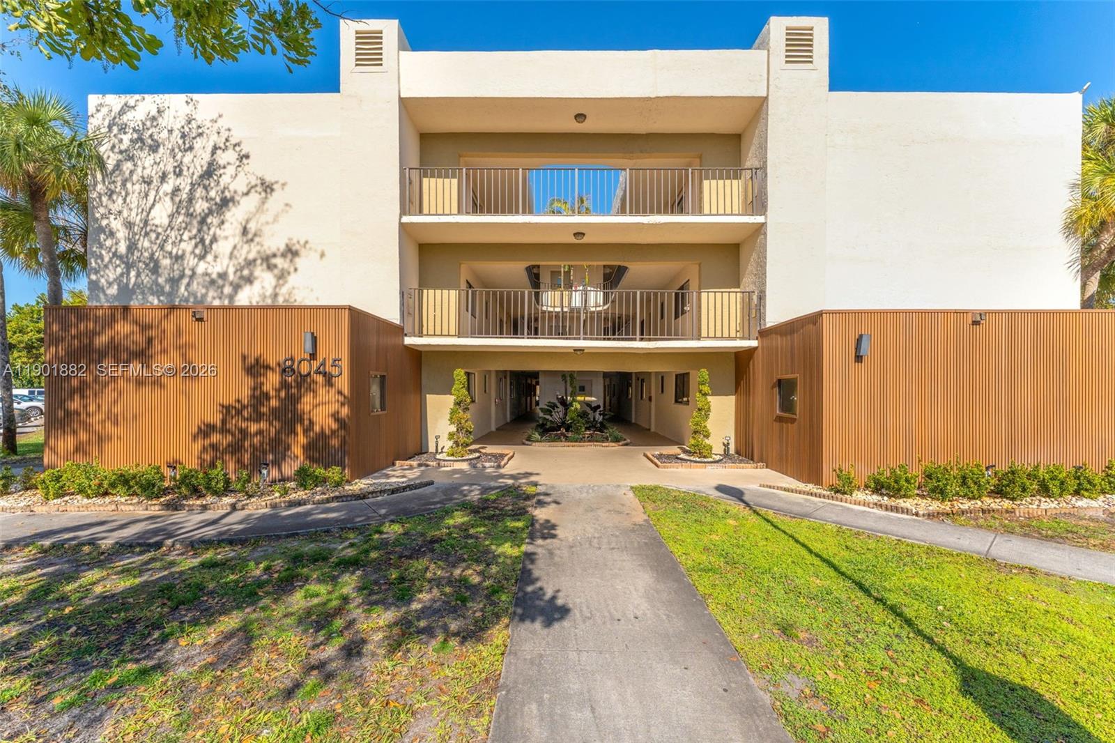 8045 Southwest 107th Avenue, Unit 303 Miami, FL 33173 - Photo 4 of 37 a front view of a house with a yard