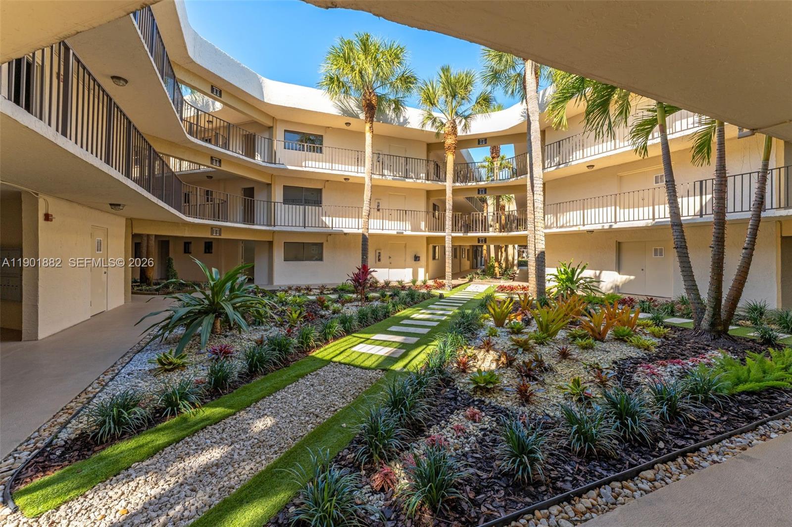 8045 Southwest 107th Avenue, Unit 303 Miami, FL 33173 - Photo 5 of 37 a front view of a multi story residential apartment building with a yard