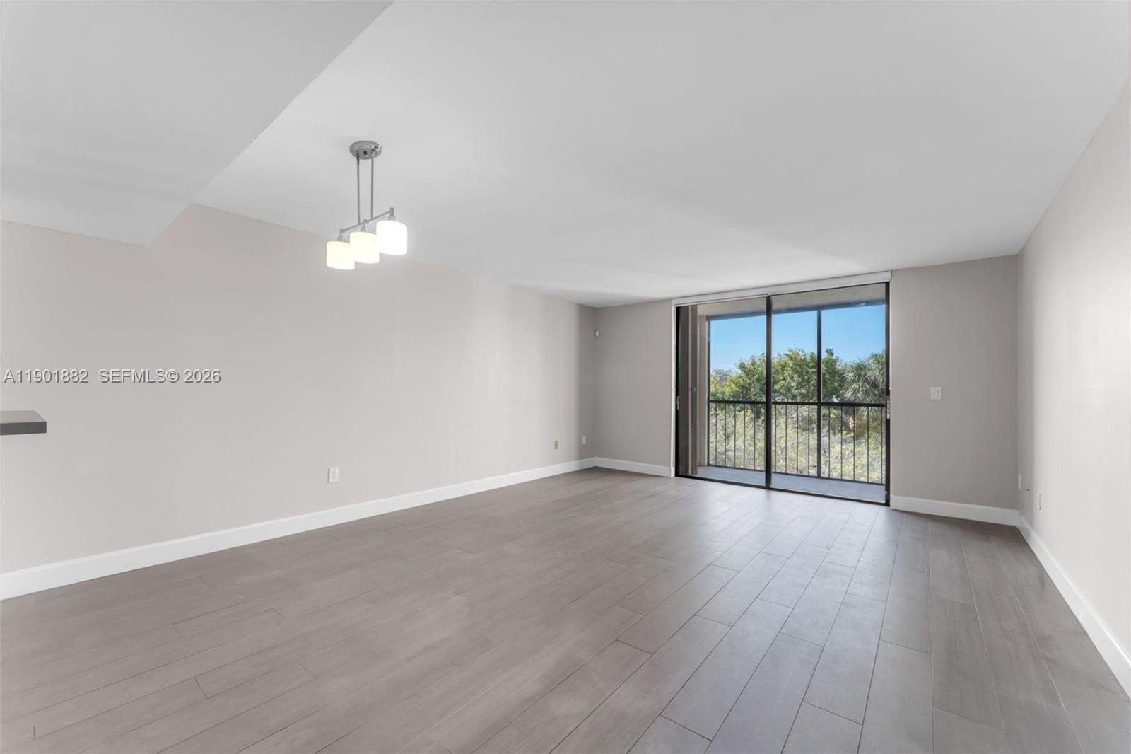 8045 Southwest 107th Avenue, Unit 303 Miami, FL 33173 - Photo 7 of 37 a view of an empty room with wooden floor and a window