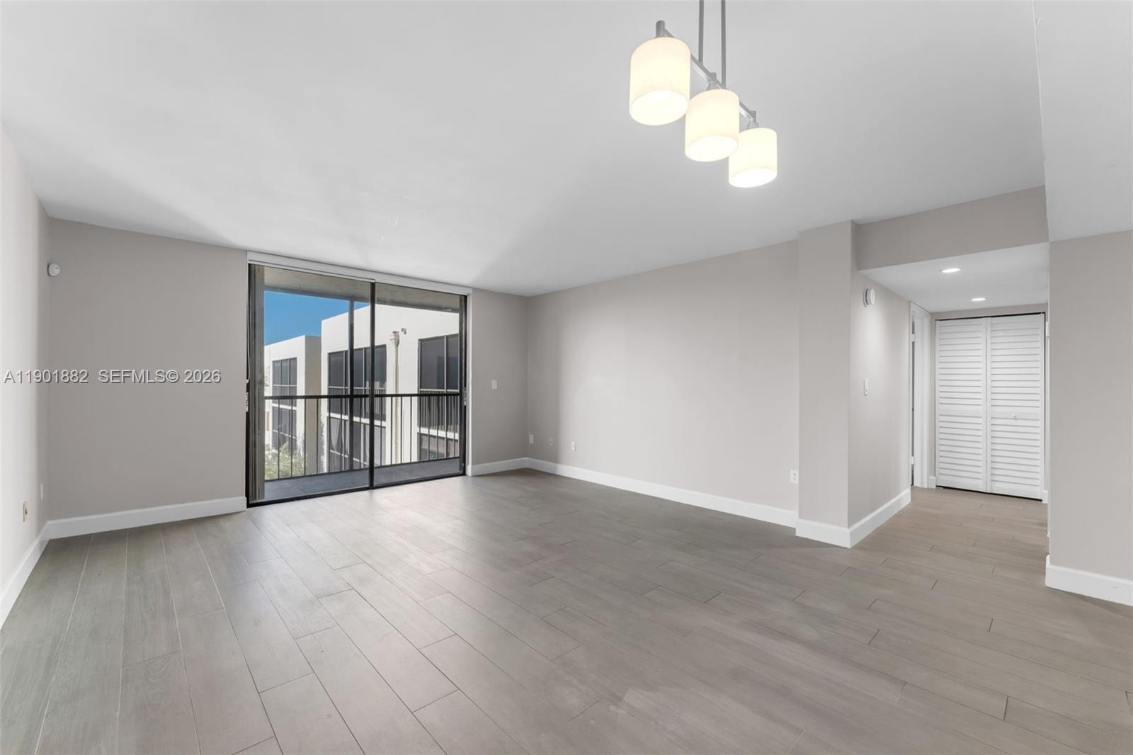 8045 Southwest 107th Avenue, Unit 303 Miami, FL 33173 - Photo 10 of 37 a view of an empty room with wooden floor and a window